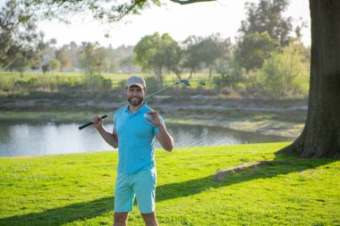 Golfçü yeşil golf topuna vuruyor..