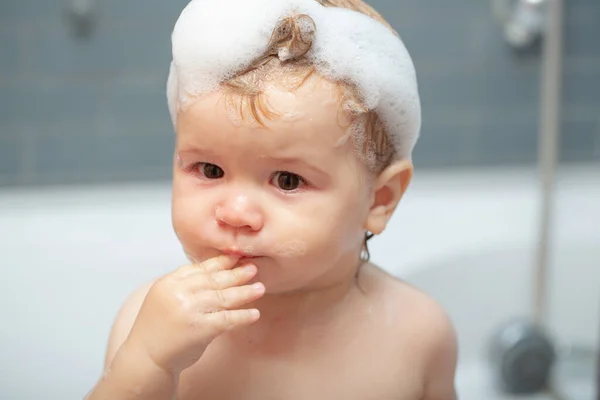 Bebé lavado de niños en un baño de espuma. Los chicos graciosos se enfrentan de cerca. Niño bañándose en la bañera. — Foto de Stock