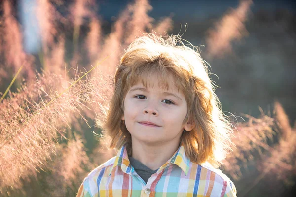 Feche-se menino loiro bonito. Conceito de emoções infantis. Retrato de criança sorridente jovem ao ar livre ou fora. — Fotografia de Stock