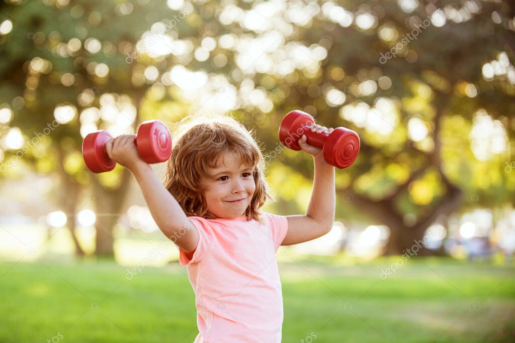 Boy workout in park. Kid sport. Child exercising with dumbbells. Sporty child with dumbbell outdoor. Kids sport. Kids active healthy lifestyle.