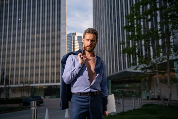 Caucasian business man in suit comes out office. concept of end working day. Sexy fashion businessman, open shirt. — Stock Photo, Image