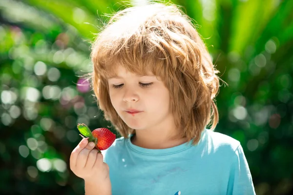 Glückliches Kleinkind mit frischen Erdbeeren. — Stockfoto