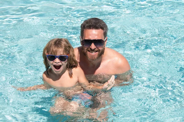 Vader en zoon zwemmen in het zwembad, zomerfamilie. Gelukkige familie in het zwembad tijdens het zomerweekend. Zwemlessen. Vader zoon vrije tijd. — Stockfoto