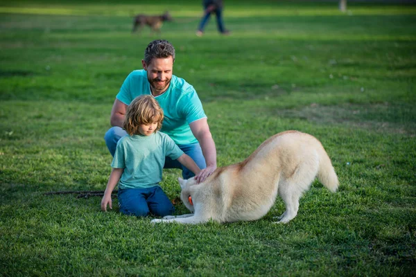 자연에 개가 있는 아버지와 아들. 개와 친근 한 가족에 대한 개념. 애완 동물 친구와 함께 한 자녀. — 스톡 사진