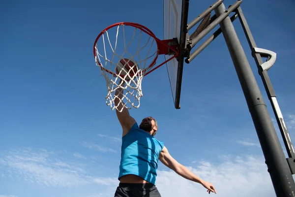 Amerikaanse basketbalspeler scoort een slam dunk. — Stockfoto