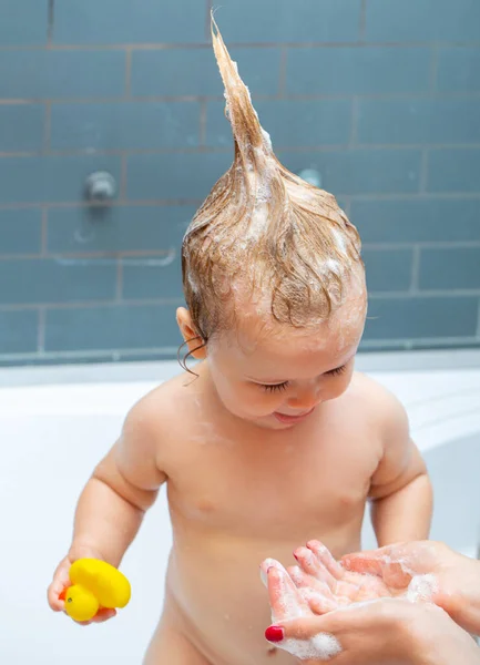 Mosolygó gyönyörű baba fürdés a zuhany alatt. A kisbaba fürdeti a haját.. — Stock Fotó