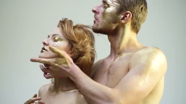 Sensueel stel met gouden make-up. Modekunst make-up. Gouden gezicht portret. — Stockvideo