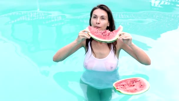 Сексуальная женщина ест арбуз в бассейне. Летние фрукты. Сезон фрукты, летняя вечеринка, закуски. — стоковое видео
