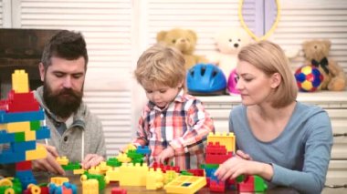 Oyuncak tuğlalı çocuk. Ebeveynlik ve ebeveynlik kavramı. Aile bloklarla oynuyor. Mutlu çocuk anne ve babasıyla oynuyor..