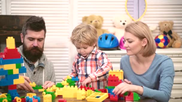 Child with toy bricks. Parenting and parenthood concept. Family playing with blocks. Happy kid playing with mother and father. — Stock Video