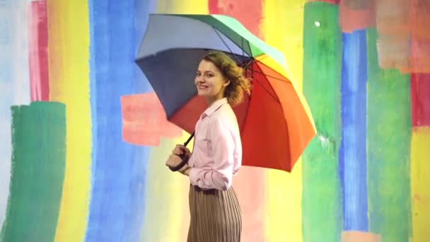 Tempo piovoso. Autunno in vena. Donna pioggia con ombrello arcobaleno. Sfondo astratto. — Video Stock