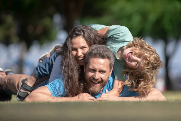Aile eğlence zamanı. Parkta sarılıp kucaklaşan mutlu bir ailenin portresi.. — Stok fotoğraf