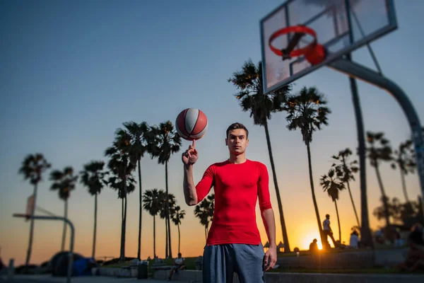 Basketbalista střelba míč v obruče venkovní hřiště. Městská hra mládeže. Ručně točící se koš. Rovnováha basketbalu na prstu. Koncepce sportovního úspěchu, bodování bodů a vítězství. — Stock fotografie