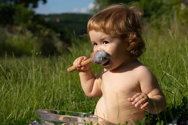 Bebê engraçado bonito com colher na boca. — Fotografia de Stock