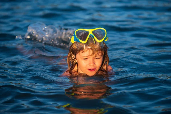 Junge schwimmen in den Sommerferien am Strand. Glückliche Kinder, die im Wasser schwimmen. Kleiner Junge schwimmt in Ozean oder Meer. — Stockfoto