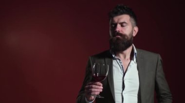 Sommelier şarabın tadını alır. Şarap kadehli adam. Yakışıklı sakallı erkek pahalı içki içiyor..