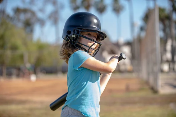 Chłopak trzyma kij bejsbolowy. Piłkarskie dziecko rzucające młodzieżowym baseballem. — Zdjęcie stockowe