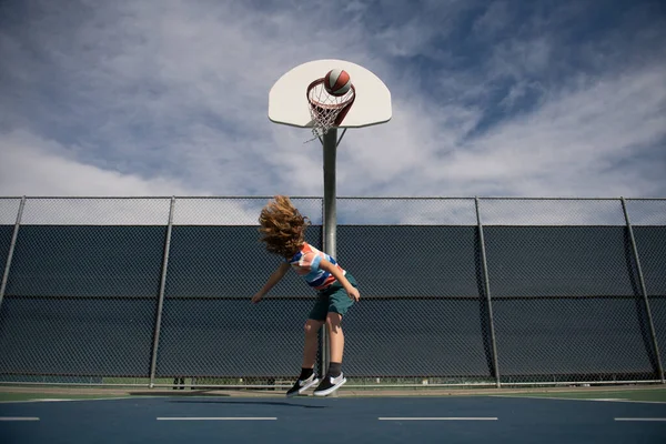 Glücklicher kleiner Junge spielt Basketball auf Spielplatz. — Stockfoto