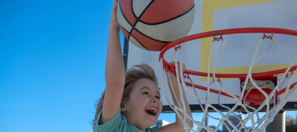 Dětská sportovní aktivita. Děti hrajou basketbal. Dětský životní styl. Detailní tvář dítě basketbalista dělat slam dunk. — Stock fotografie