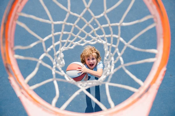 Visão superior da criança animada jogando basquete segurando bola com rosto feliz. — Fotografia de Stock