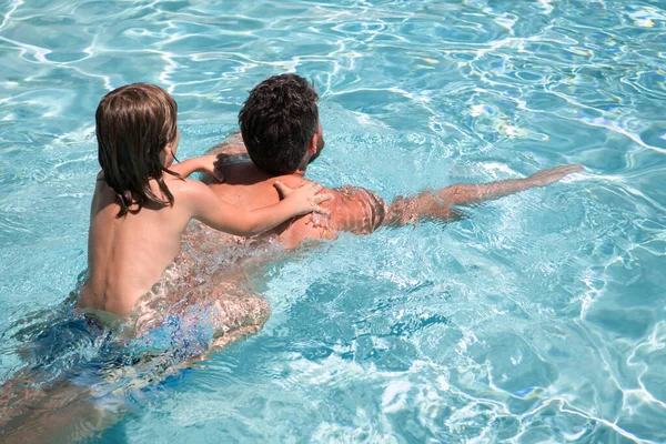 Father and son swimming in pool, summer family. Child pool party. Family leisure. Summer vacation. Father and son in pool. Child with dad playing in swimmingpool. — Stock Photo, Image