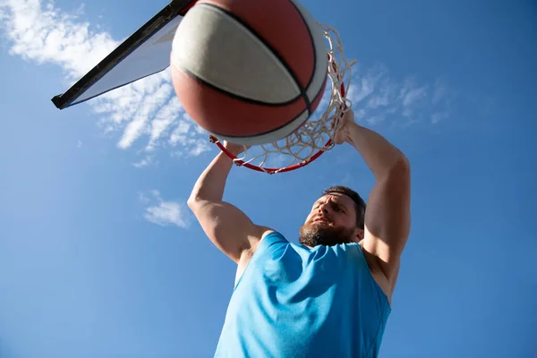 Close-up beeld van professionele basketbalspeler maken slam dunk tijdens basketbal spel in outdoor basketbalveld. — Stockfoto