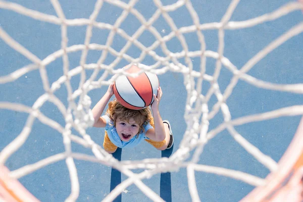 Jogo de basquetebol. Kid treinamento com bola cesta na quadra de basquete ao ar livre. — Fotografia de Stock