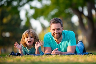 Mutlu baba ve gülümseyen oğul dışarıda birlikte vakit geçiriyorlar. Arkadaş canlısı aile kavramı.