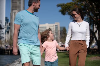 Ailesi ve oğlu şehirde yürüyor. Aile sokakta yürüyüş yapıyor..