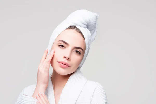 Mujer joven con toalla en la cabeza crema en la cara. Cuidado de la piel hidratante belleza spa tratamiento concepto. — Foto de Stock