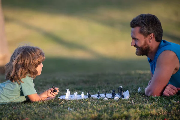 父は子供の息子とチェスをする。ゲーム外の家族. — ストック写真