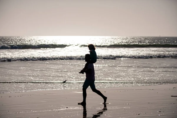 父と息子は海を歩いている。屋外で遊んでいる父と子供. — ストック写真