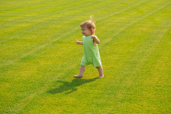 Bebé en el hermoso campo verde de primavera. Niño sano. — Foto de Stock