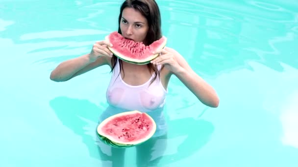 Sommerurlaub. Sexy Frau essen Wassermelone im Pool. Sommerfrüchte. Obst der Saison, Snacks für Sommerfeste. — Stockvideo