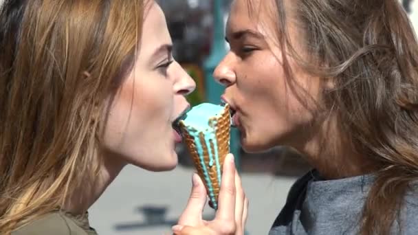 Amizade feminina. Duas raparigas comem gelado. Mulheres a lamber gelados. Quente dia de verão. — Vídeo de Stock