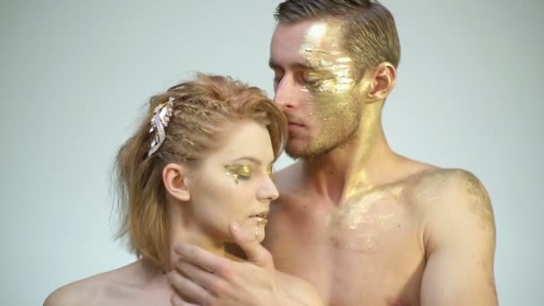 Een kus van een gouden paar. Sensueel stel met gouden make-up. Mode kunsthuid. vrouw goud gezicht portret closeup. — Stockvideo