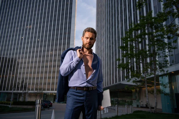 Portrait of a handsome CEO. Excited businessman in suit. Young handsome man. Confident sexy business man portrait with jacket over shoulder, open shirt. — Stock Photo, Image