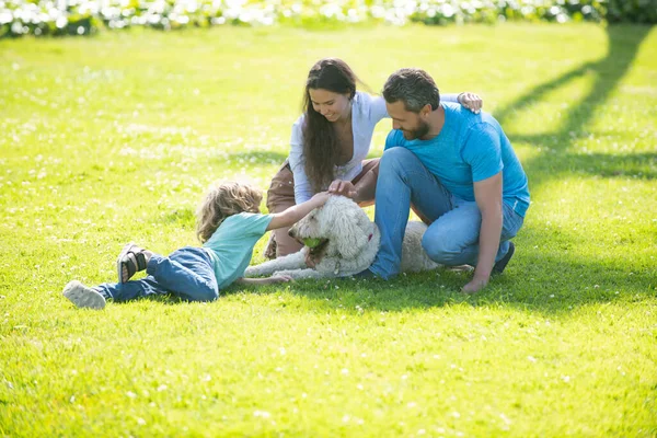 Portrait d'une famille souriante heureuse avec chien de compagnie relaxant dans le parc. — Photo