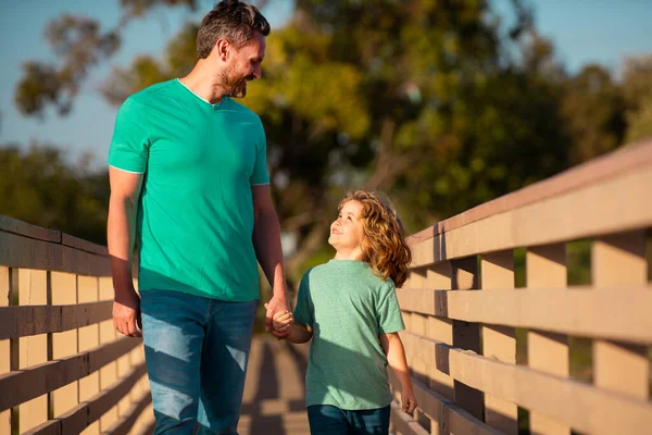 Vader en zoon genieten van gezelschap, praten, plezier hebben in de natuur op zonnige dag. Ouderschap, levensstijl, ouderschap, kinder- en gezinsleven. — Stockfoto