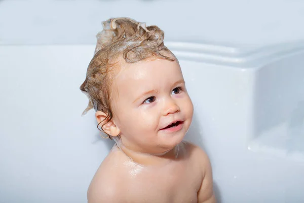 Gyerek fürdés. Boldog baba vesz egy fürdőt játszik hab buborékok. Kisgyerek a fürdőkádban. Mosolygós gyerek a fürdőszobában játékkacsával. Csecsemőmosás és fürdés. Gyerekgondozás és higiénia. — Stock Fotó