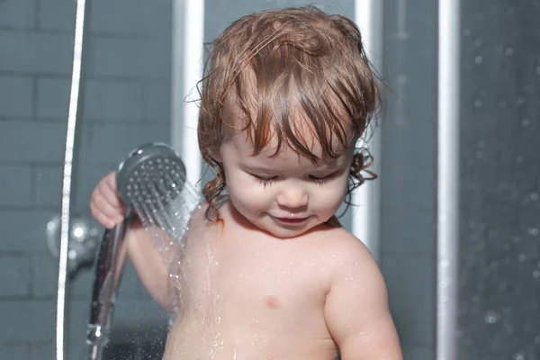 Bain d'enfant dans la salle de bain. Petit bébé enfant se lave les cheveux dans le bain. — Photo