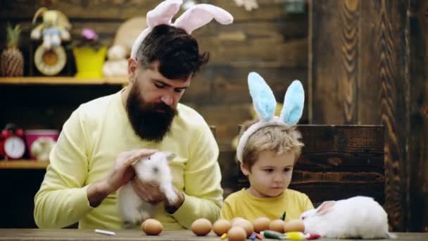 Padre e hijo con conejitos de Pascua. Papá y niño en orejas de conejo. Relaciones familiares. — Vídeos de Stock