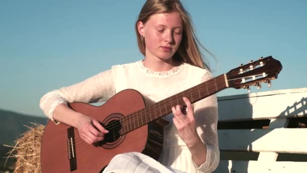 Девушка-музыкант играет на гитаре. Женщины расслабляются под музыку. — стоковое видео