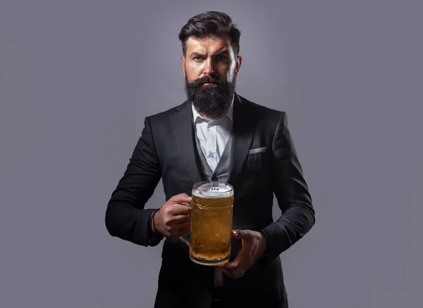Hipster with beard and mustache in suit drinks beer. Germany Bavaria. Beer time. Handsome barman holding a pint of beer. — Stock Photo, Image