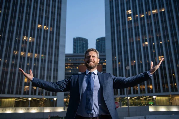 Happy smiling businessman in suit near office, successful employer to make a deal while standing near skyscraper office at night. — Stock Photo, Image
