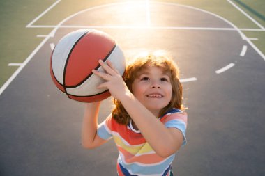 Basketbol oynayan sevimli bir çocuk. Sportif çocuk portresi.