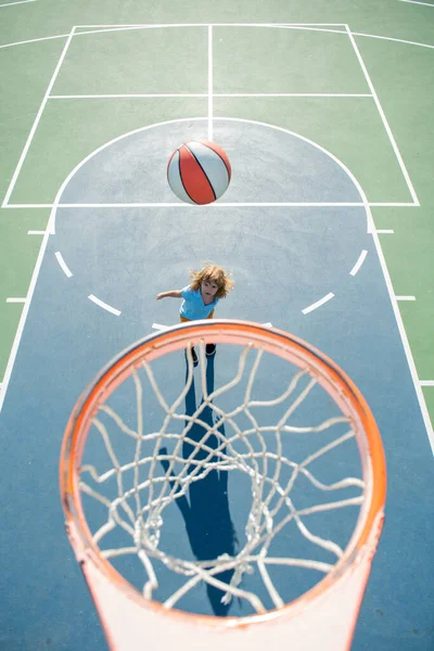 Bovenaanzicht van een kind dat basketbal speelt. Een gezonde levensstijl voor kinderen. Kids sport activiteit. — Stockfoto