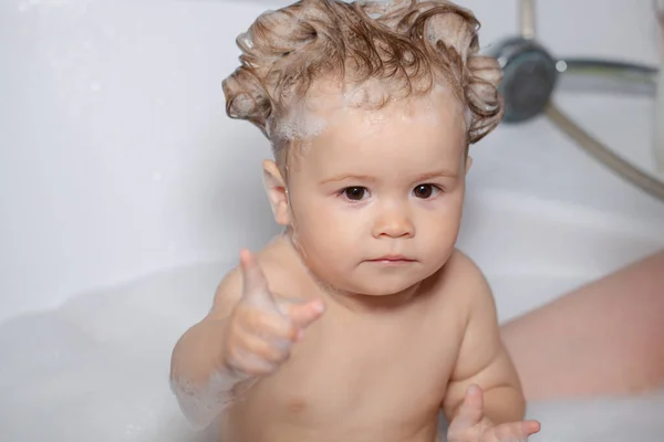 Το παιδί κάνει μπάνιο στο μπάνιο. Βρεφική μπανιέρα με αφρό και σαπουνόφουσκες. — Φωτογραφία Αρχείου