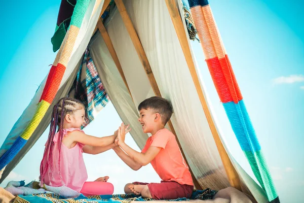 Crianças casal brincando na tenda. Acampar. Atividade ao ar livre de verão. Feliz conceito de infância. Miúdos giros. — Fotografia de Stock