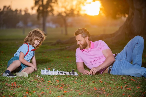 Father play chess with son. Family outside game. Young boy beating a man at chess. — Stock Photo, Image